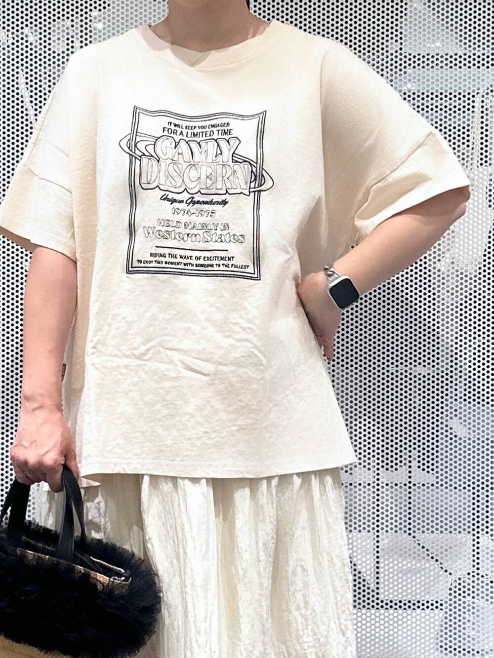 ベージュ系のショルダーバッグ、ホワイト系のスカート、ブラック系のバレッタ/ヘアクリップを着用したレディースの夏コーディネートの4枚目の写真