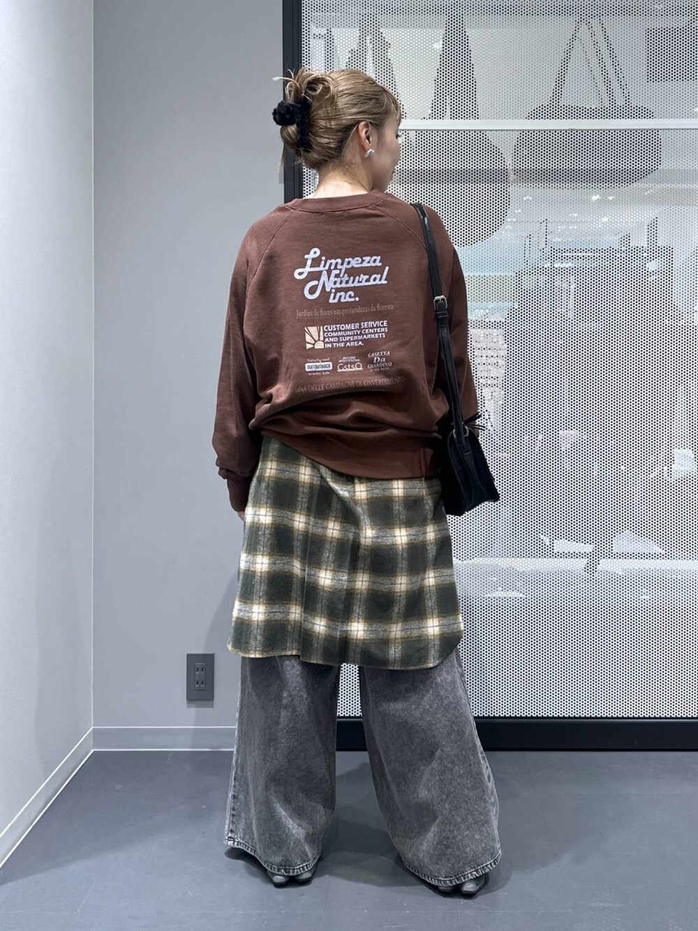 ブラック系のショルダーバッグ、ブラック系のデニムパンツ、グリーン系のシャツ/ブラウスを着用したレディースの秋コーディネートの2枚目の写真
