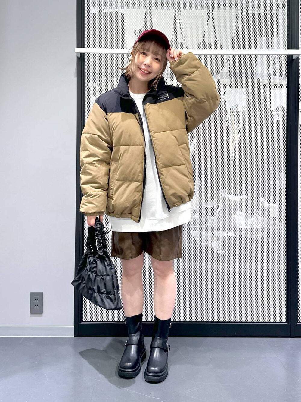 ベージュ系のブルゾン、ブラック系のブーツ、ホワイト系のスウェットを着用したレディースの冬コーディネートの3枚目の写真