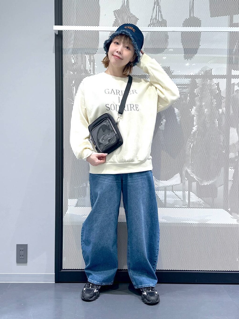 グレー系のスニーカー、ブルー系のデニムパンツ、グリーン系のミリタリージャケットを着用したレディースの冬コーディネートの2枚目の写真