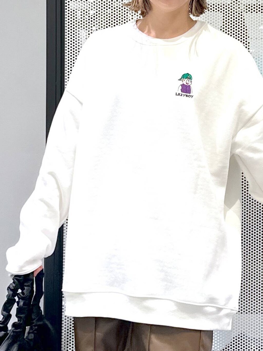 ベージュ系のブルゾン、ブラック系のブーツ、ホワイト系のスウェットを着用したレディースの冬コーディネートの8枚目の写真