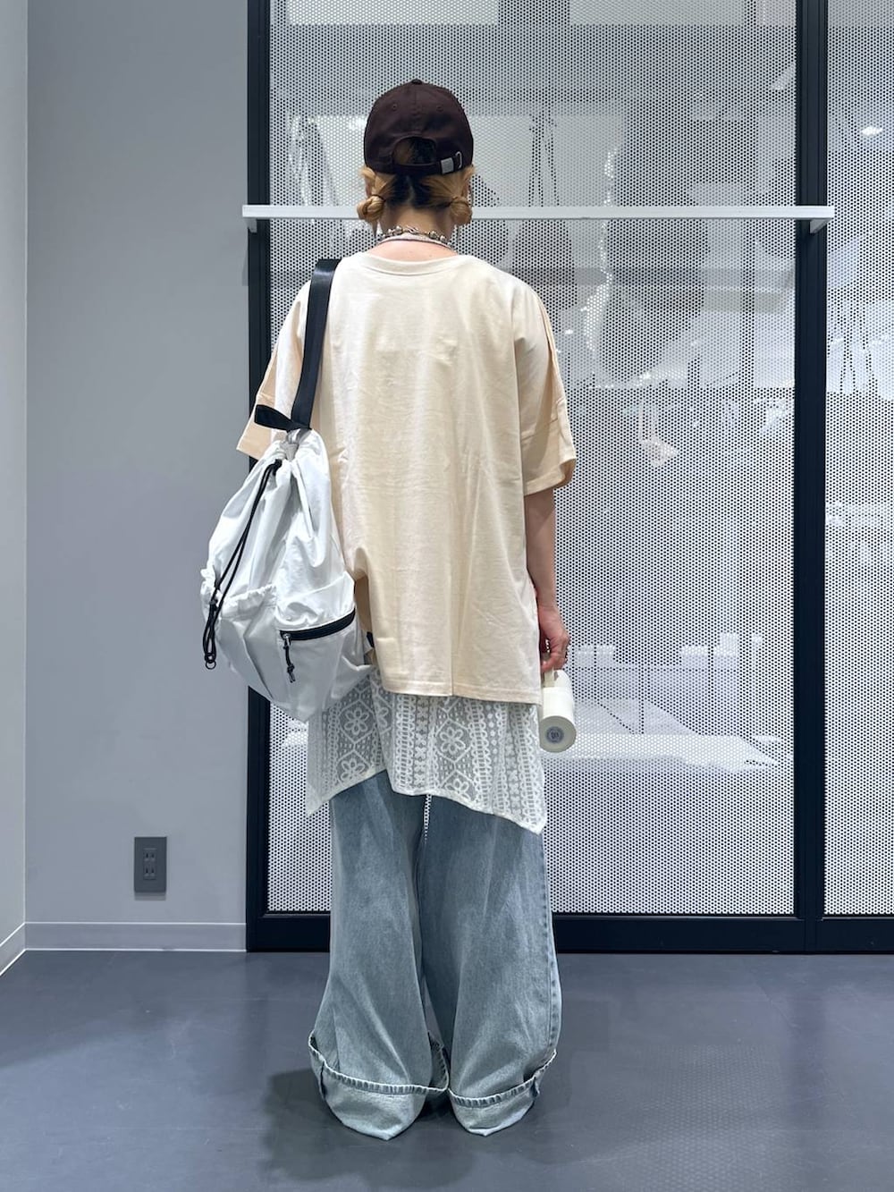 ホワイト系のショルダーバッグ、ブルー系のデニムパンツ、ベージュ系のワンピースを着用したレディースの夏コーディネートの3枚目の写真