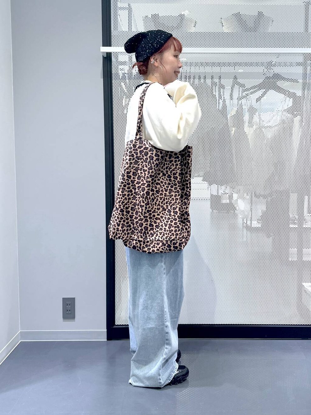 グレー系のスニーカー、ベージュ系のトートバッグ、ブルー系のデニムパンツを着用したレディースの秋コーディネートの3枚目の写真