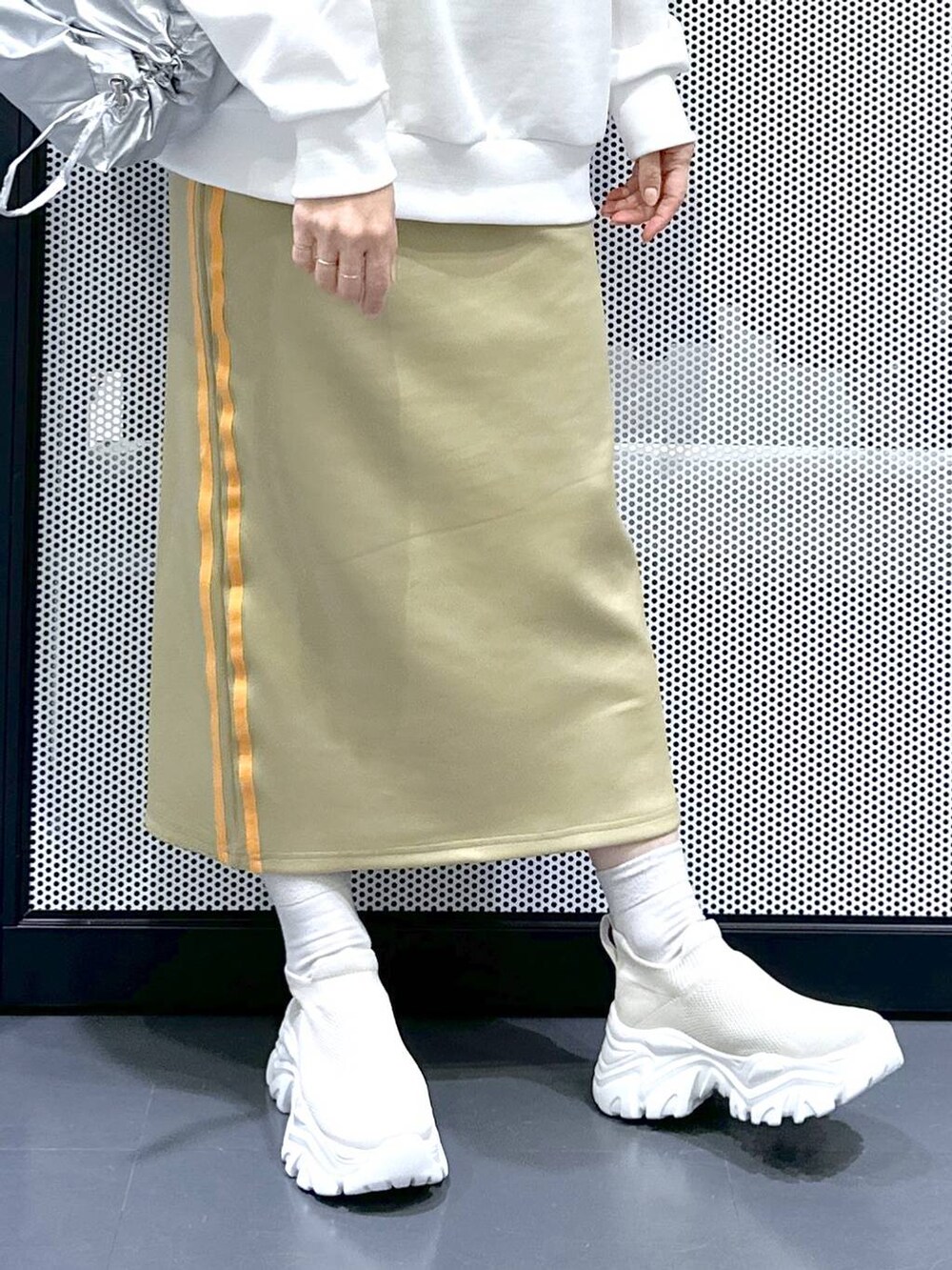 グリーン系のスカート、シルバー系のショルダーバッグ、ブラック系のシュシュを着用したレディースの冬コーディネートの7枚目の写真