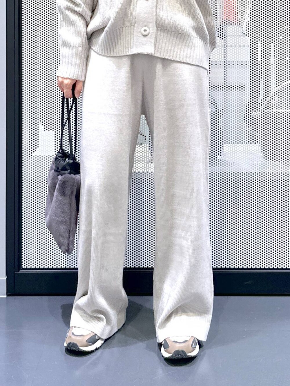 ブラウン系のスニーカー、グレー系のカーディガン/ボレロ、グレー系のその他パンツを着用したレディースの秋コーディネートの5枚目の写真