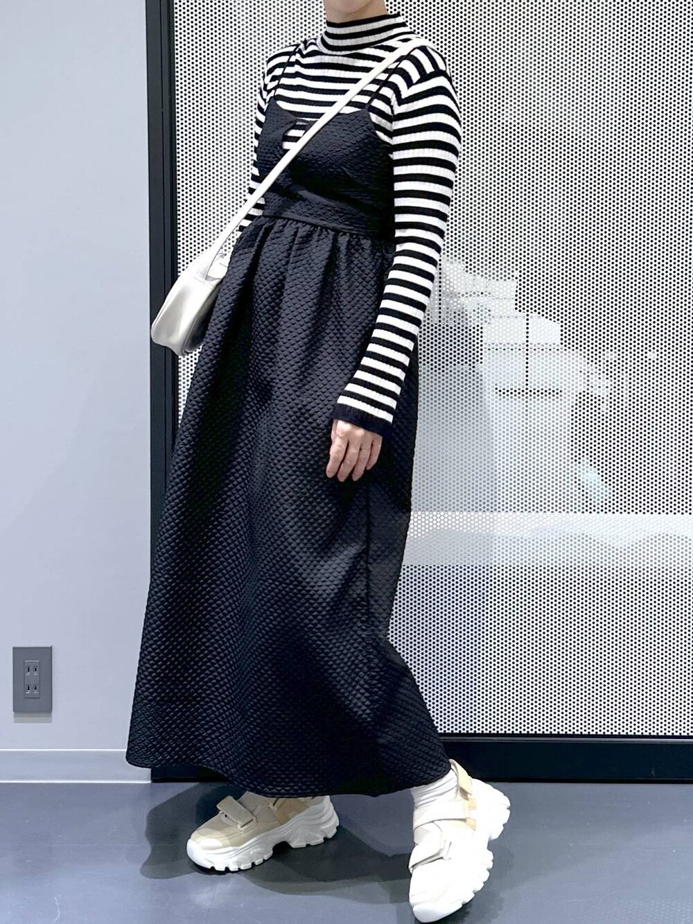 ベージュ系のスニーカー、ブラック系のワンピース、ホワイト系のショルダーバッグを着用したレディースの冬コーディネートの4枚目の写真