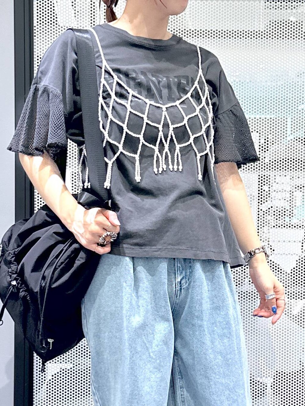 ブラック系のショルダーバッグ、ブルー系のデニムパンツ、ホワイト系のベストを着用したレディースの夏コーディネートの6枚目の写真