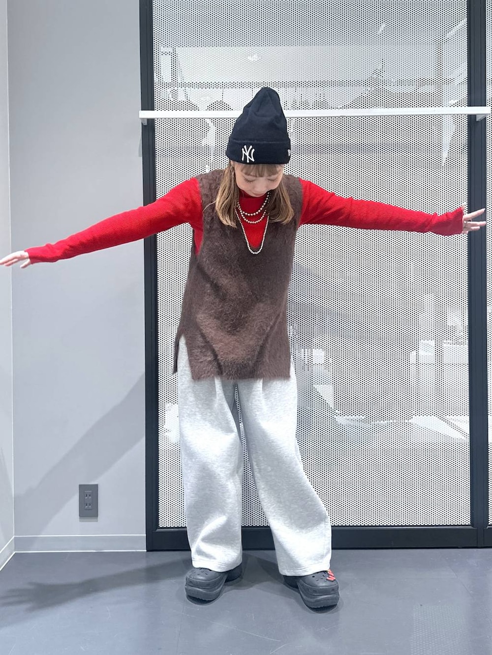 ブラック系のブルゾン、ブラック系のショルダーバッグ、ブラウン系のベストを着用したレディースの冬コーディネートの2枚目の写真