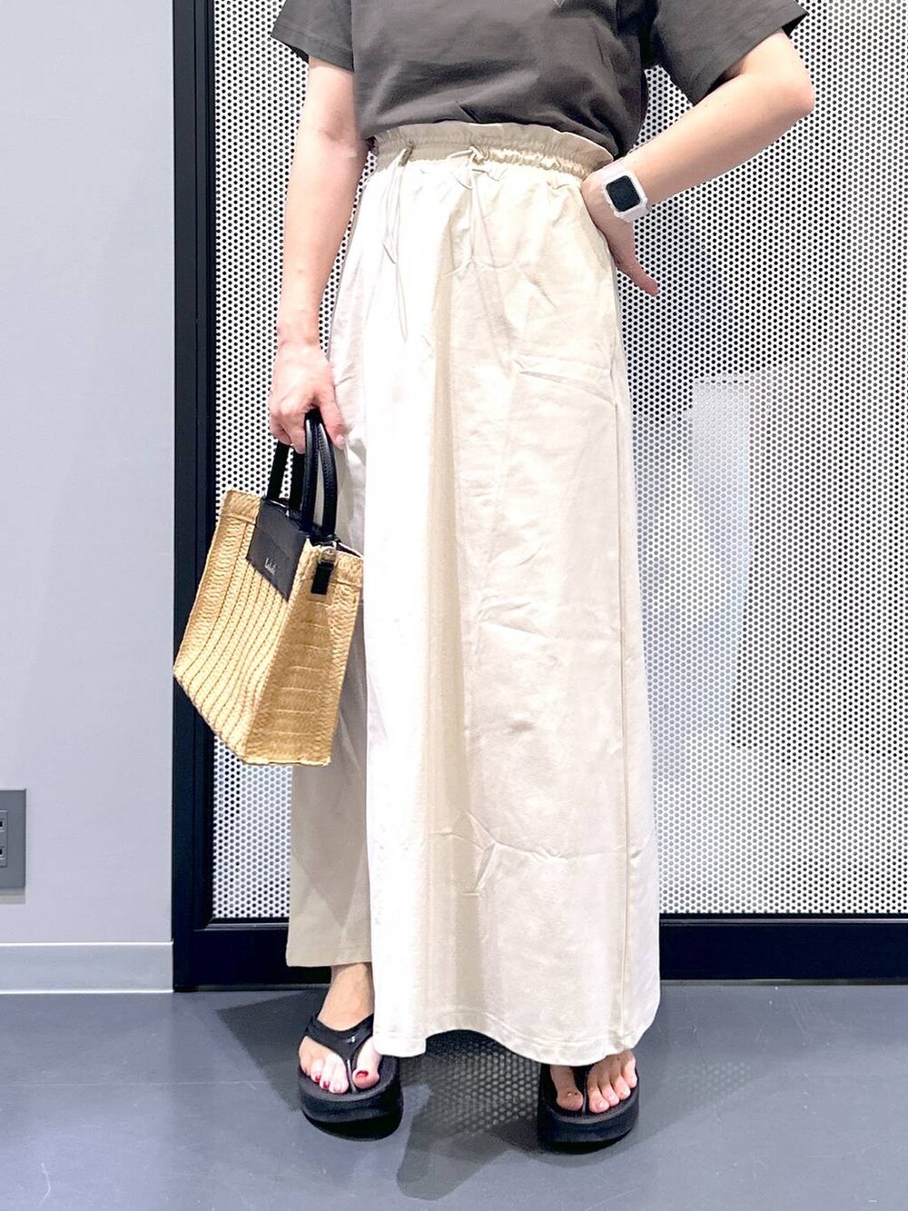 ベージュ系のスカート、ブラック系のサンダル、ベージュ系のショルダーバッグを着用したレディースの夏コーディネートの6枚目の写真