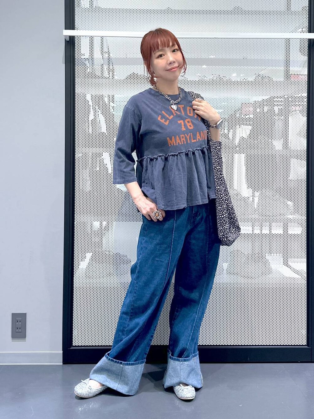 ブラック系のトートバッグ、シルバー系のパンプス、ブルー系のデニムパンツを着用したレディースの夏コーディネートの5枚目の写真