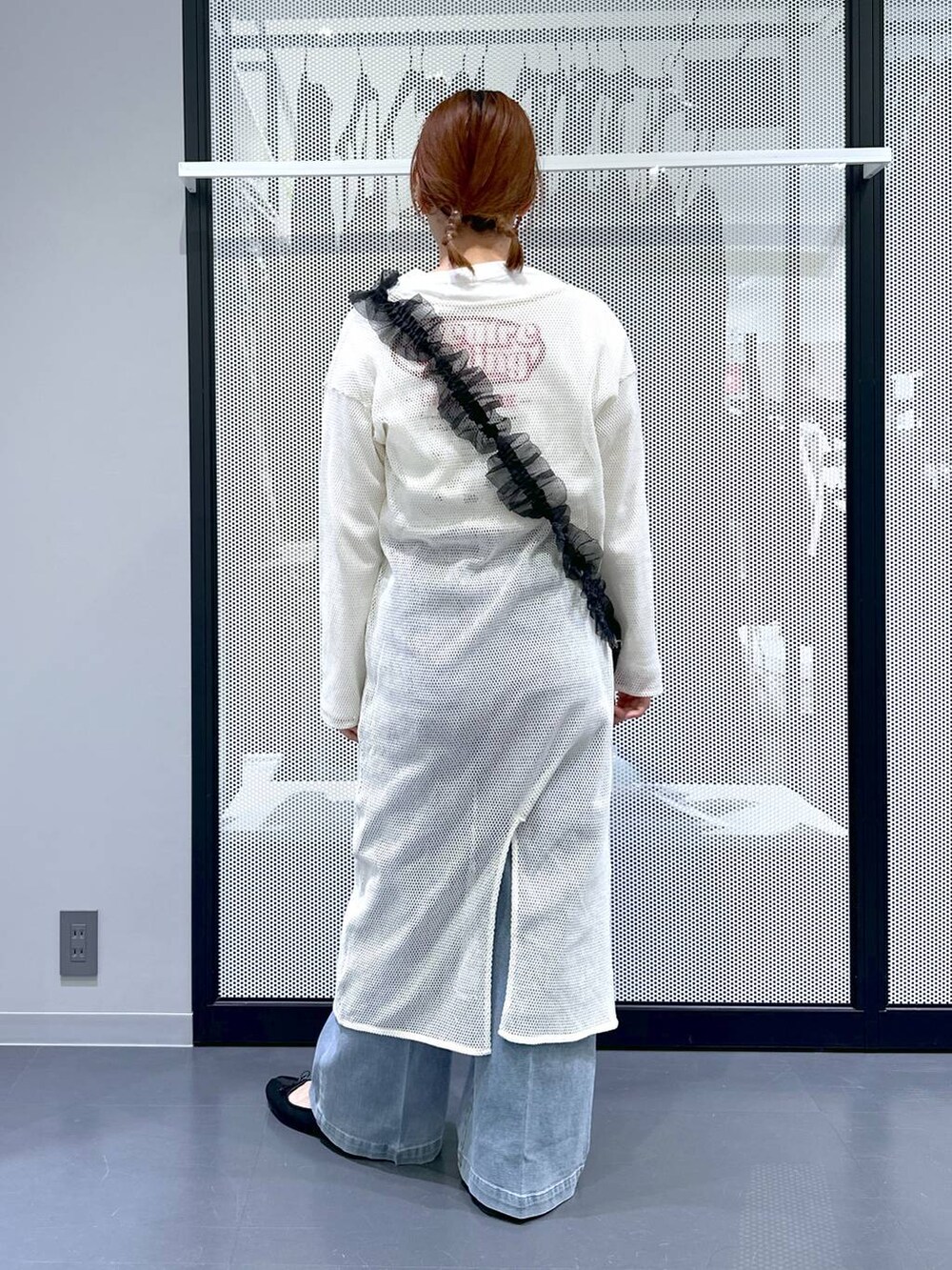 ブルー系のデニムパンツ、ホワイト系のワンピース、ブラック系のバレエシューズを着用したレディースの春コーディネートの3枚目の写真