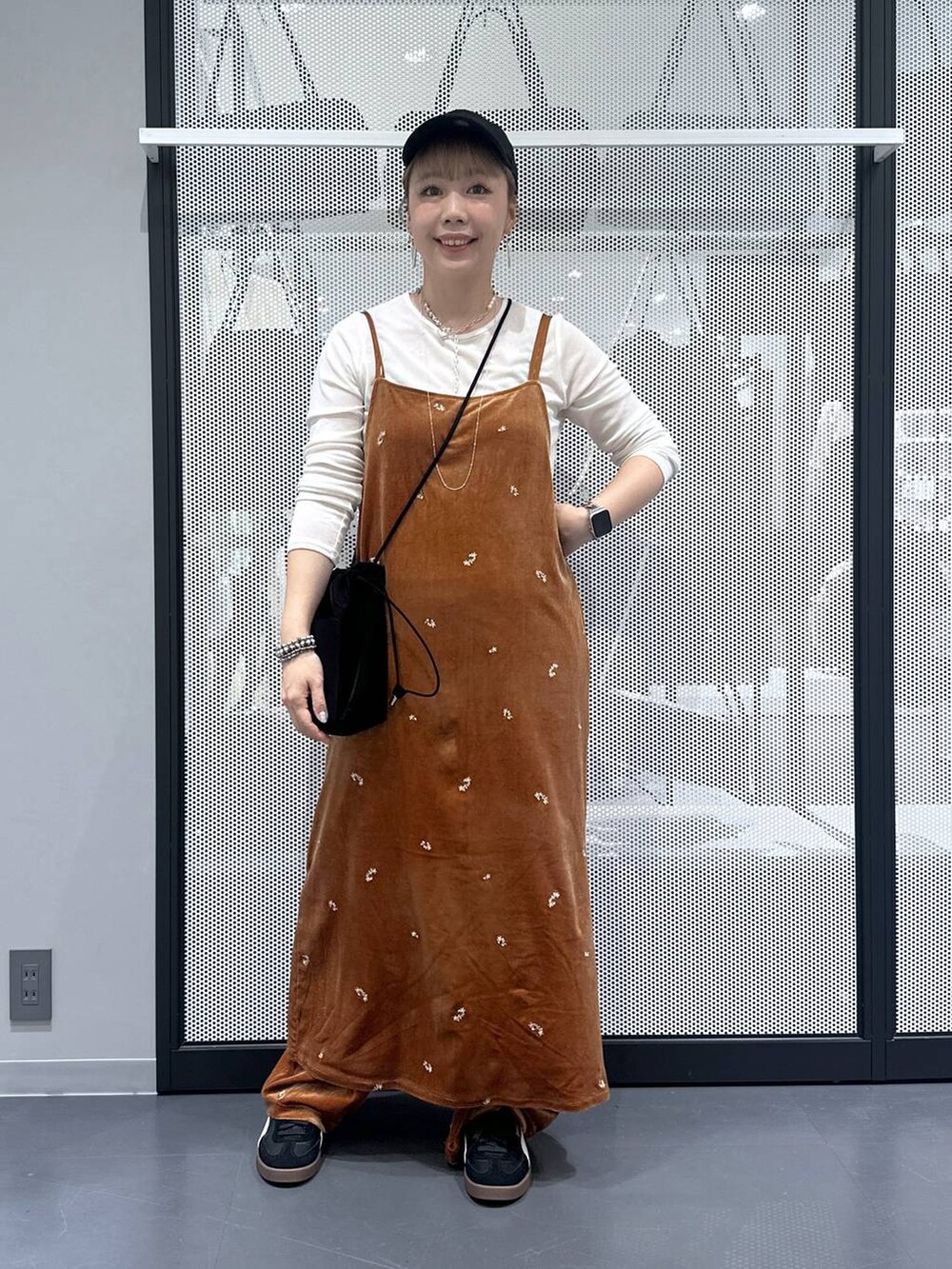 ホワイト系のTシャツ/カットソー、ブラック系のスニーカー、ブラック系のショルダーバッグを着用したレディースの秋コーディネートの2枚目の写真