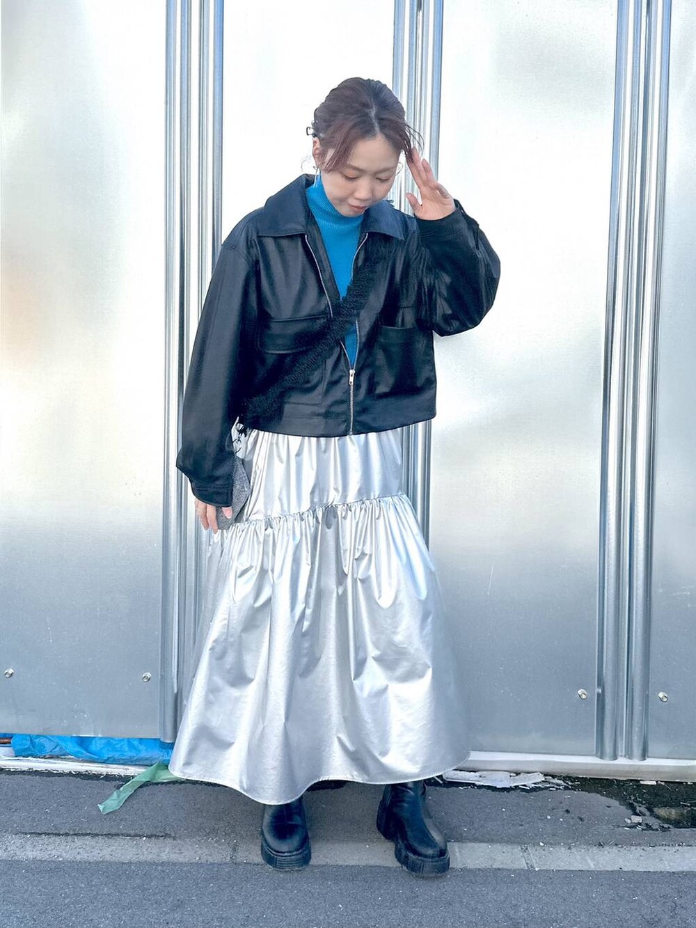 ブラック系のブルゾン、シルバー系のスカート、ブルー系のニット/セーターを着用したレディースの冬コーディネートの6枚目の写真