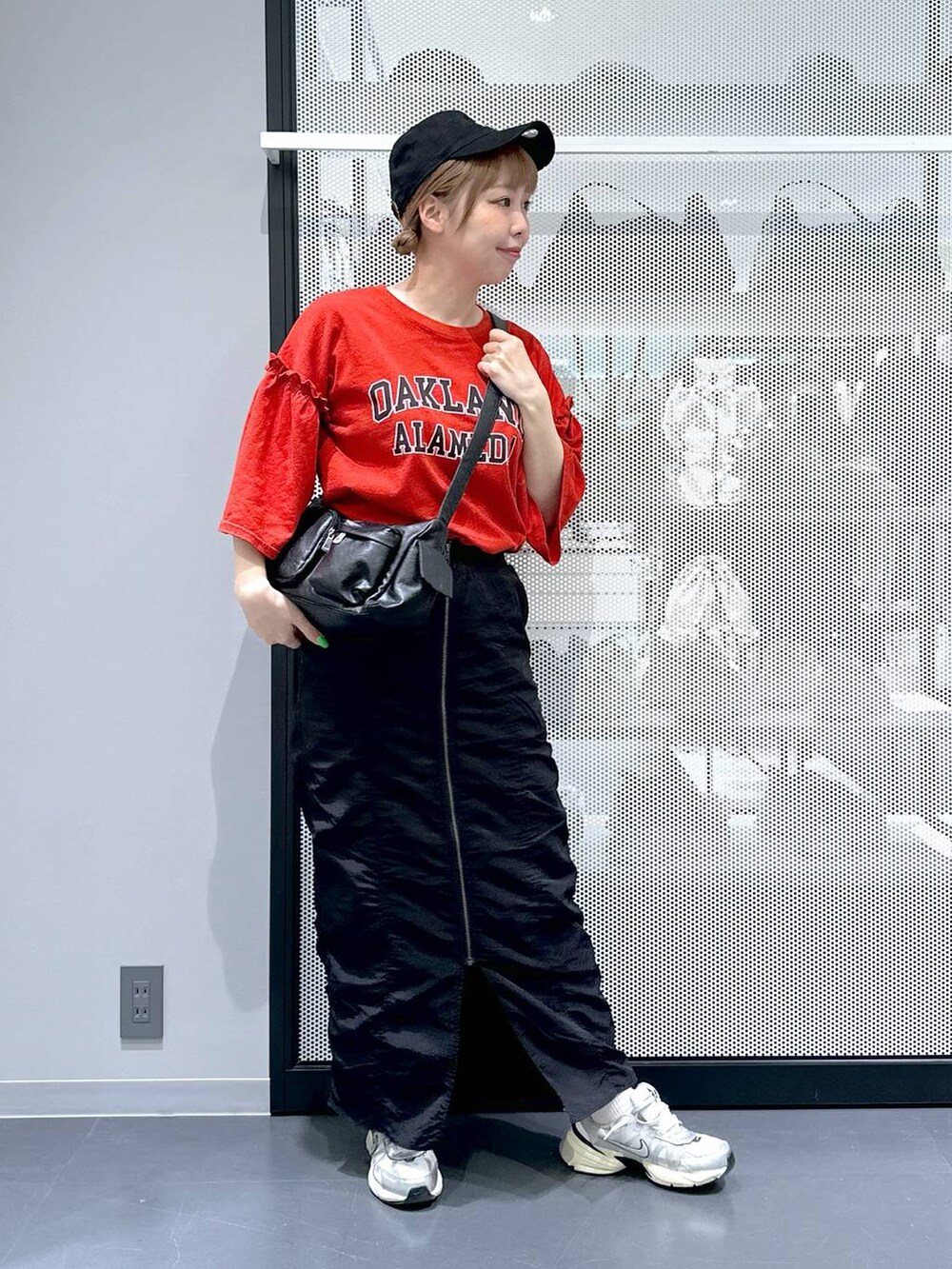 ブラック系のスカート、ブラック系のショルダーバッグ、レッド系のTシャツ/カットソーを着用したレディースの春コーディネートの6枚目の写真