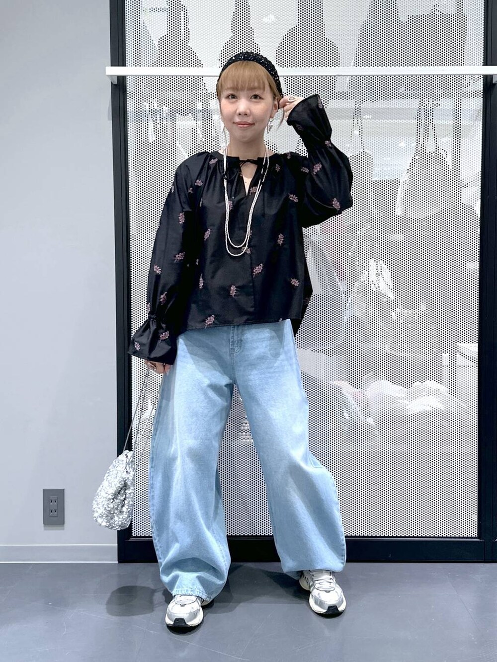 ブルー系のデニムパンツ、その他のショルダーバッグ、ブラック系のシャツ/ブラウスを着用したレディースの春コーディネートの2枚目の写真