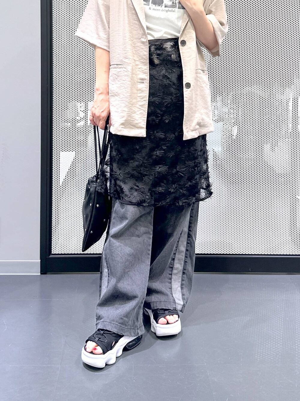 ブラック系のショルダーバッグ、ブラック系のデニムパンツ、ホワイト系のTシャツ/カットソーを着用したレディースの夏コーディネートの6枚目の写真