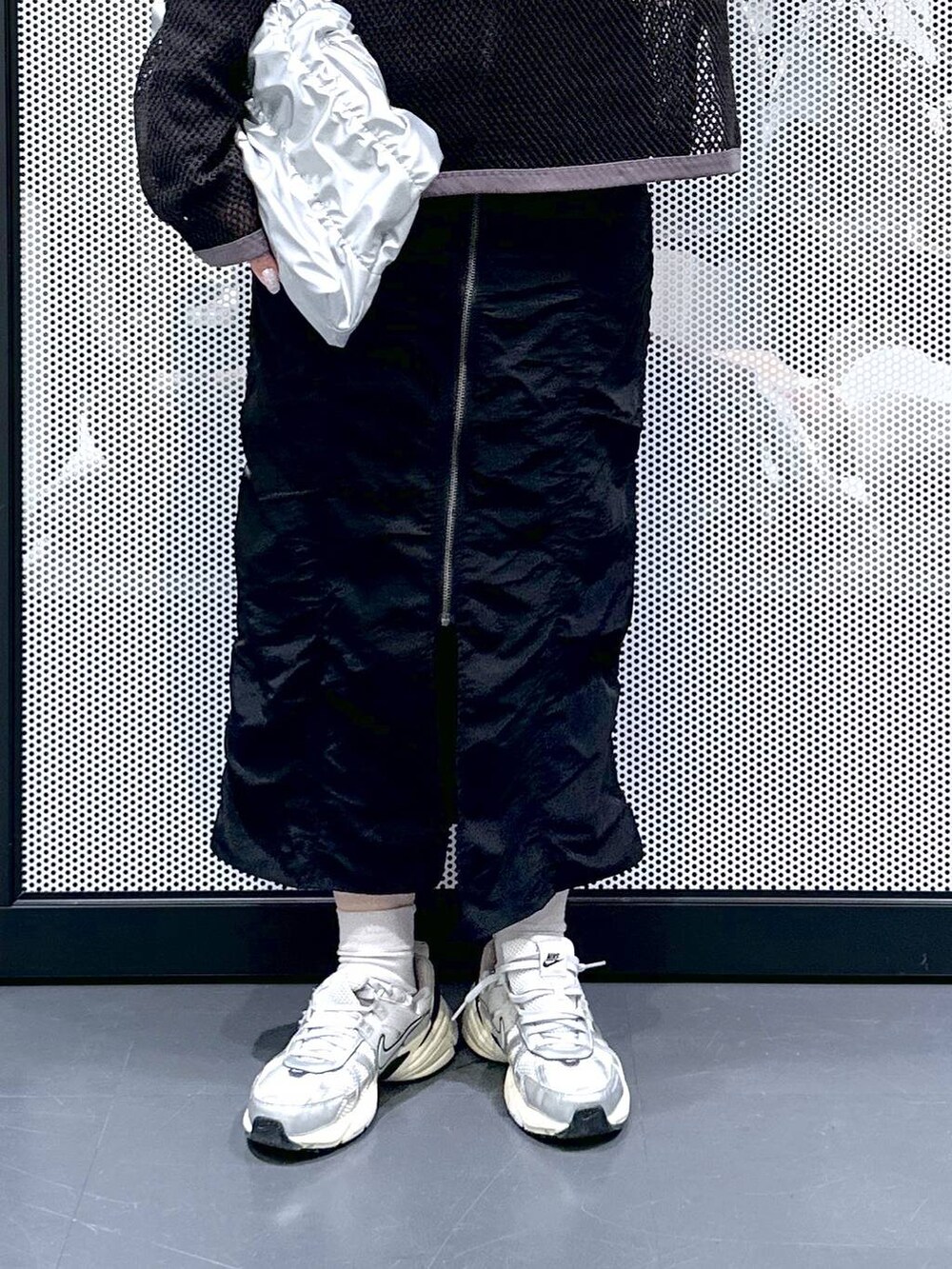 ブラック系のスカート、シルバー系のショルダーバッグ、グレー系のTシャツ/カットソーを着用したレディースの春コーディネートの4枚目の写真