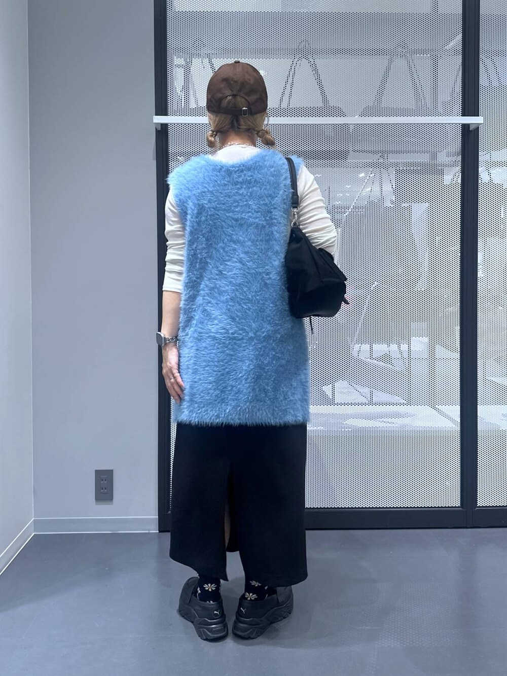 ホワイト系のTシャツ/カットソー、ブラック系のスカート、ブルー系のベストを着用したレディースの秋コーディネートの3枚目の写真