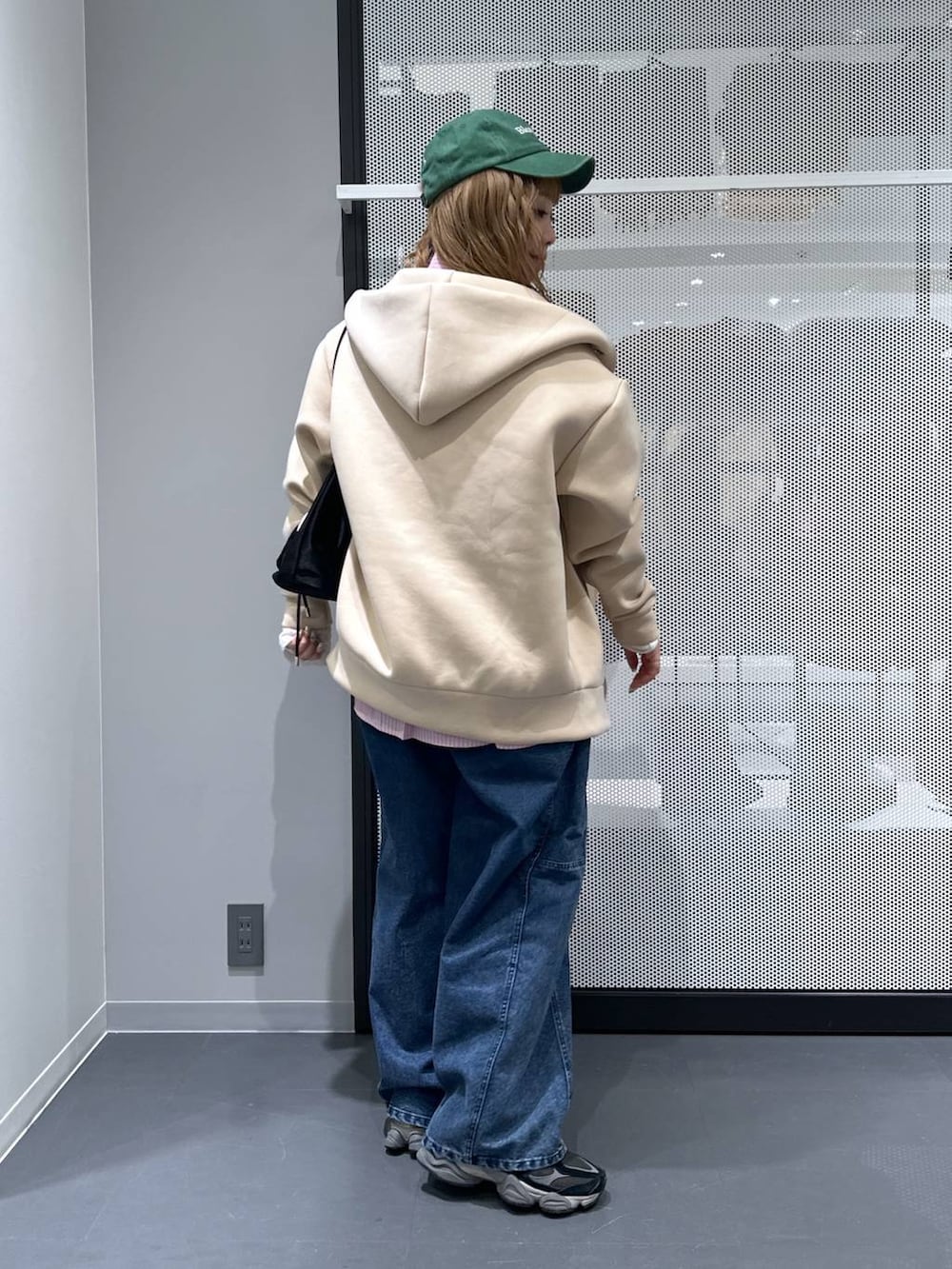 ホワイト系のTシャツ/カットソー、ブラック系のショルダーバッグ、ブルー系のデニムパンツを着用したレディースの冬コーディネートの3枚目の写真