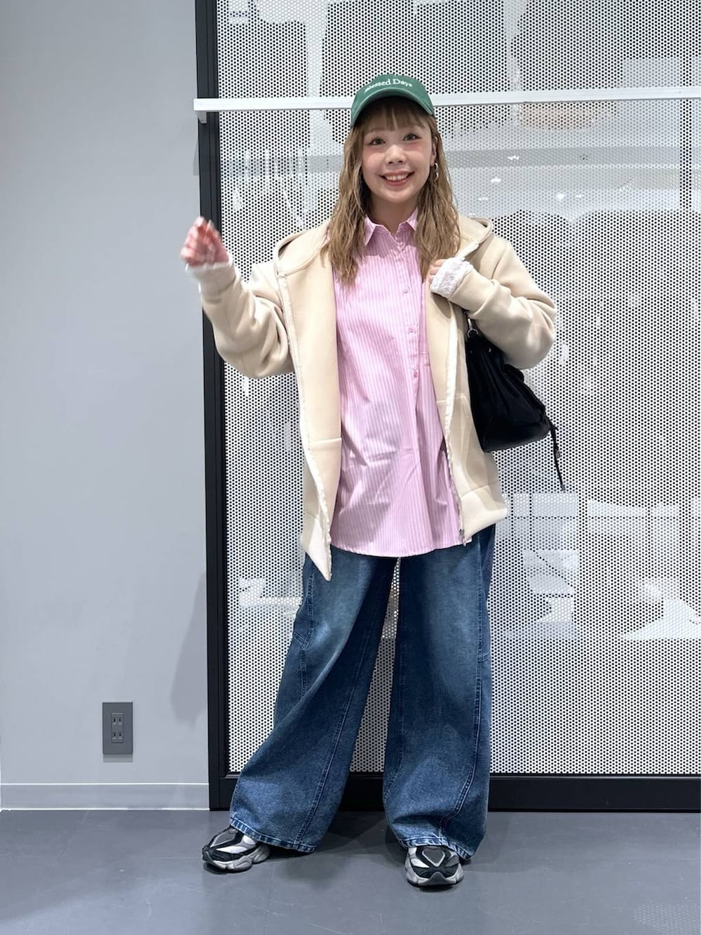 ホワイト系のTシャツ/カットソー、ブラック系のショルダーバッグ、ブルー系のデニムパンツを着用したレディースの冬コーディネートの2枚目の写真