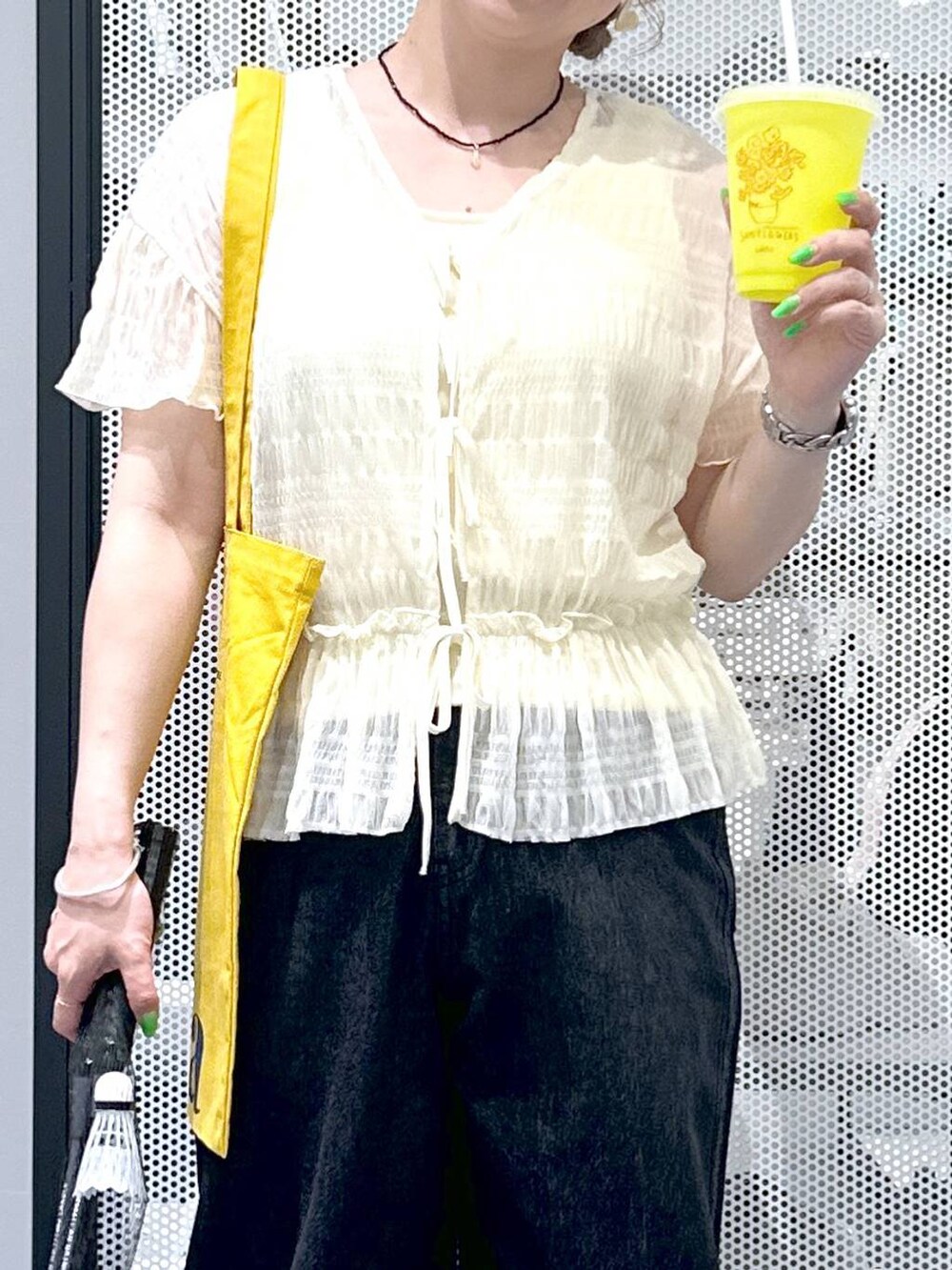 ホワイト系のカーディガン/ボレロ、ブラック系のデニムパンツ、イエロー系のトートバッグを着用したレディースの春コーディネートの5枚目の写真