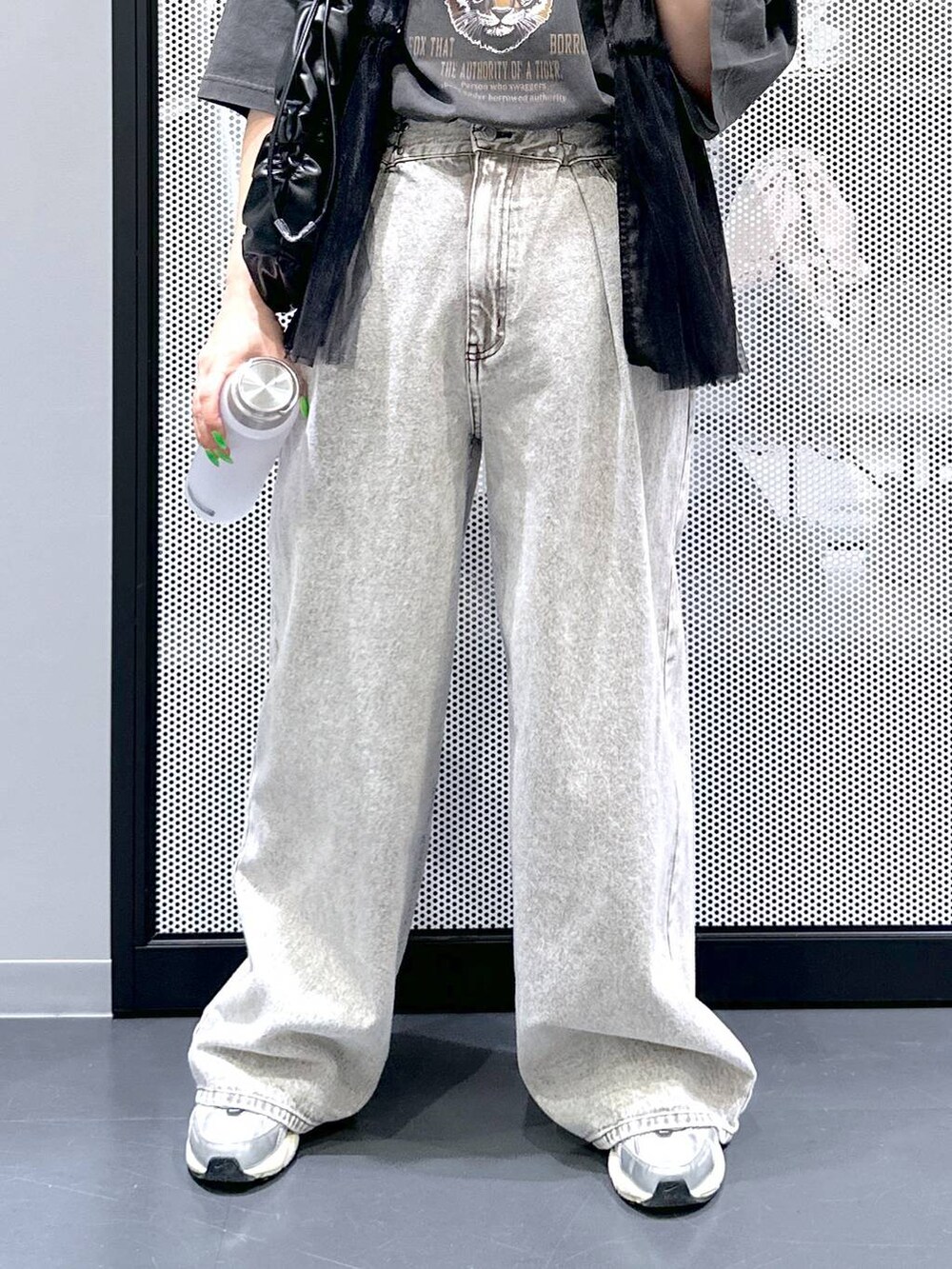 グレー系のデニムパンツ、ブラック系のベスト、グレー系のTシャツ/カットソーを着用したレディースの春コーディネートの5枚目の写真