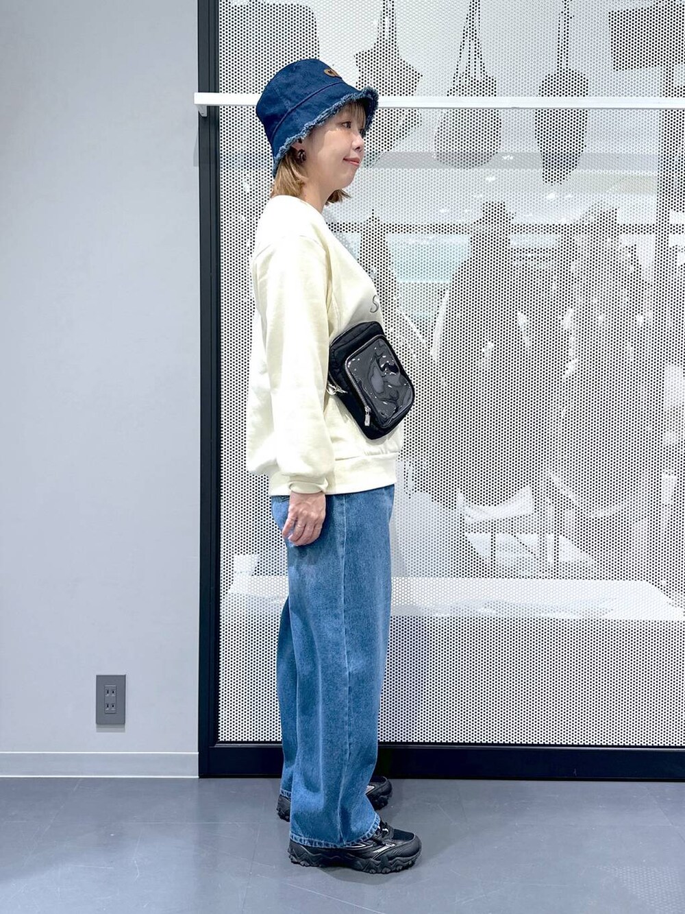 グレー系のスニーカー、ブルー系のデニムパンツ、グリーン系のミリタリージャケットを着用したレディースの冬コーディネートの3枚目の写真