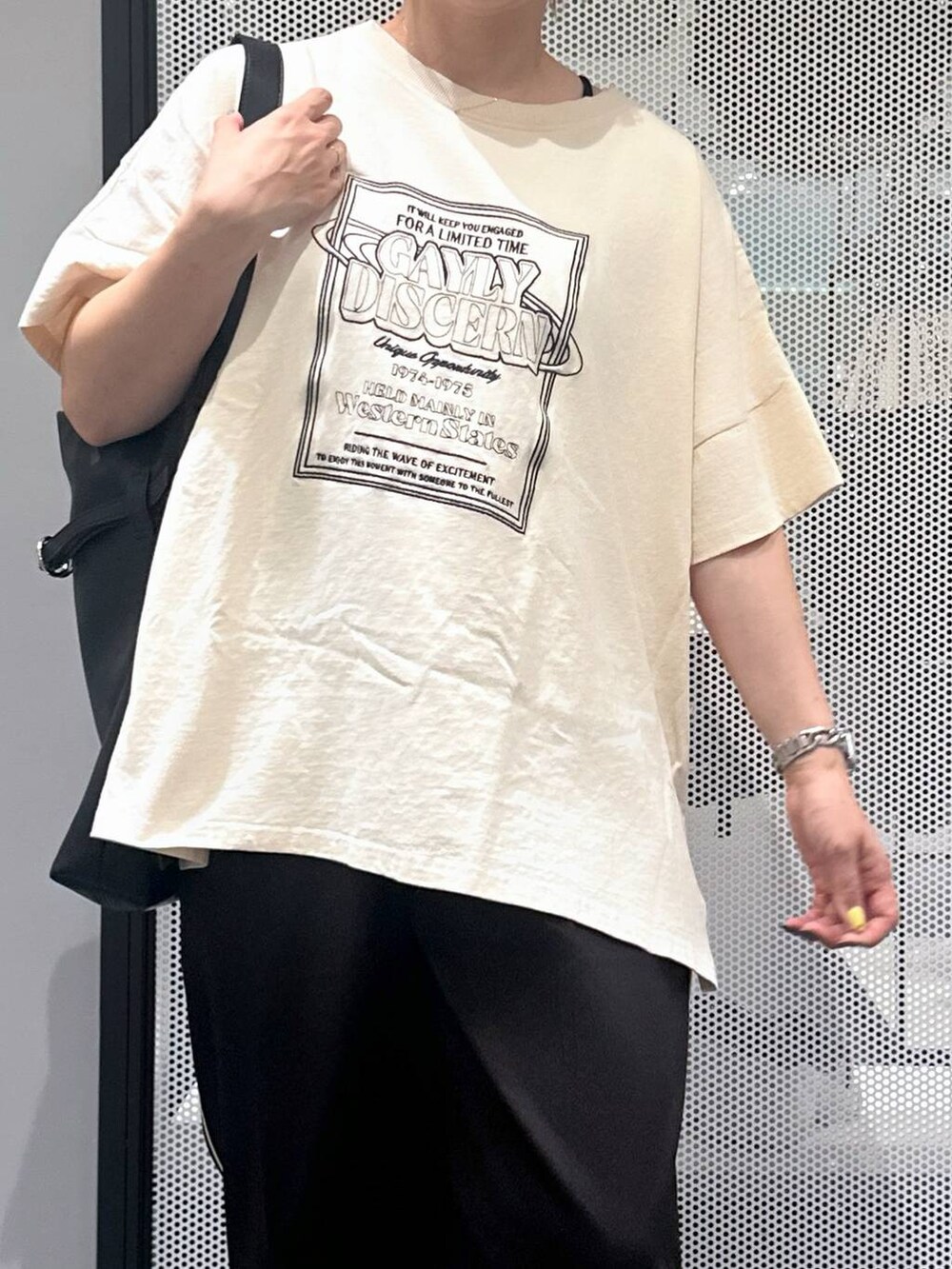 ブラック系のスラックス、ブラック系のショルダーバッグ、ブラック系のバレッタ/ヘアクリップを着用したレディースの夏コーディネートの4枚目の写真