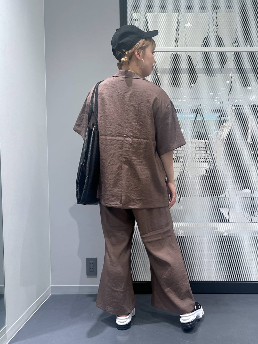 ブラック系のトートバッグ、ブラウン系のテーラードジャケット、ブラウン系のその他パンツを着用したレディースの春コーディネートの3枚目の写真