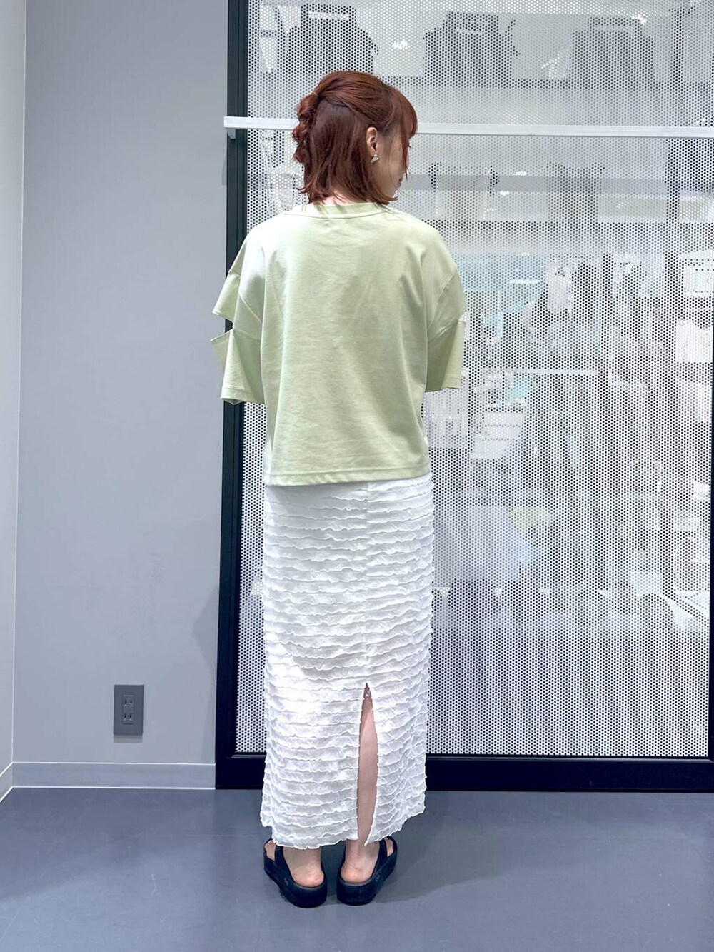 ブラック系のショルダーバッグ、ホワイト系のスカート、グリーン系のTシャツ/カットソーを着用したレディースの夏コーディネートの3枚目の写真