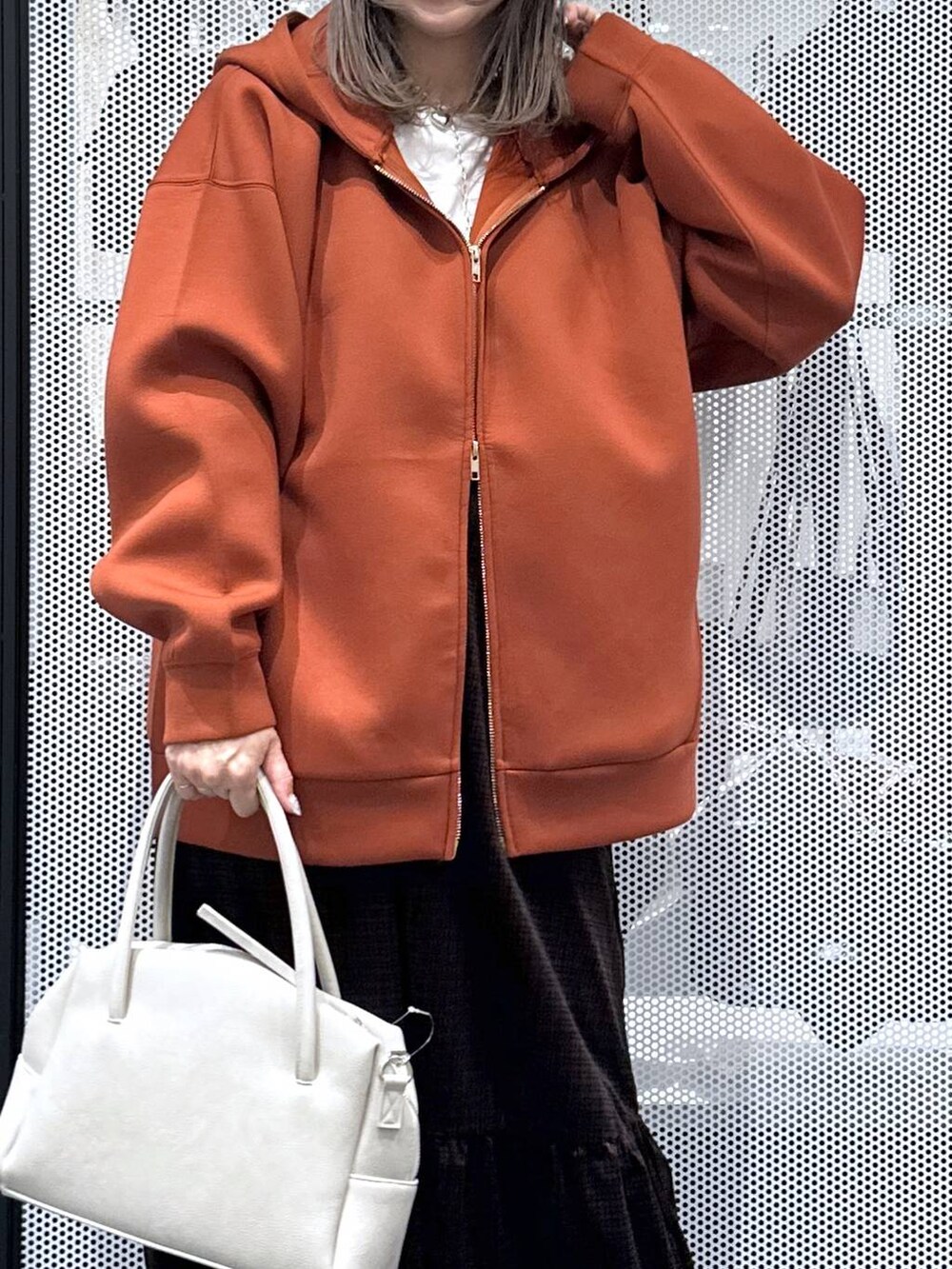 グレー系のボストンバッグ、ブラウン系のパーカー、ホワイト系のTシャツ/カットソーを着用したレディースの秋コーディネートの4枚目の写真