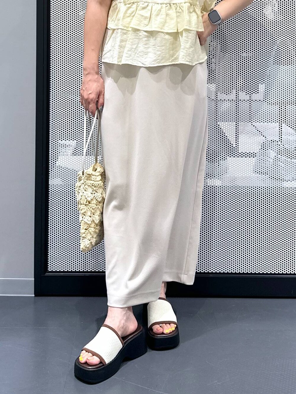 ホワイト系のサンダル、ベージュ系のショルダーバッグ、ベージュ系のスカートを着用したレディースの夏コーディネートの5枚目の写真