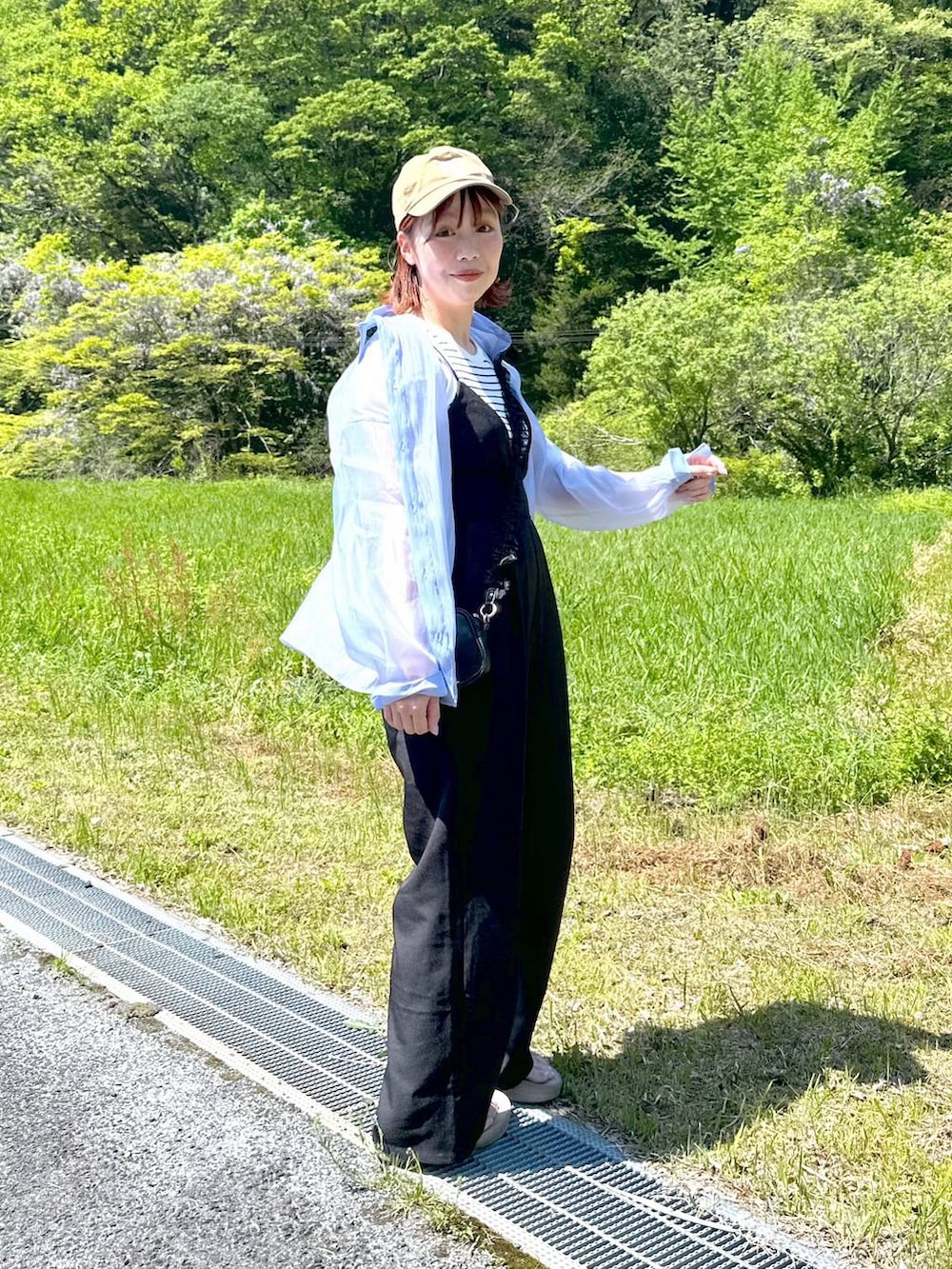 ブルー系のシャツ/ブラウス、ベージュ系のサンダル、ブラック系のサロペット/オーバーオールを着用したレディースの春コーディネートの2枚目の写真