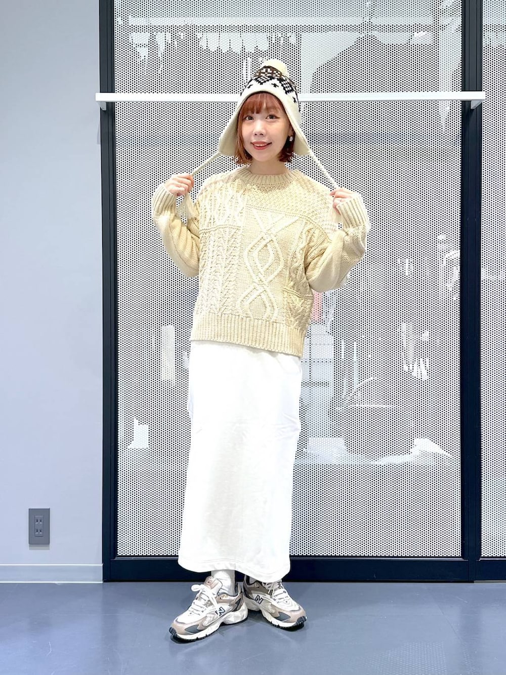 ブラウン系のスニーカー、ベージュ系のショルダーバッグ、グリーン系のナイロンジャケットを着用したレディースの冬コーディネートの6枚目の写真