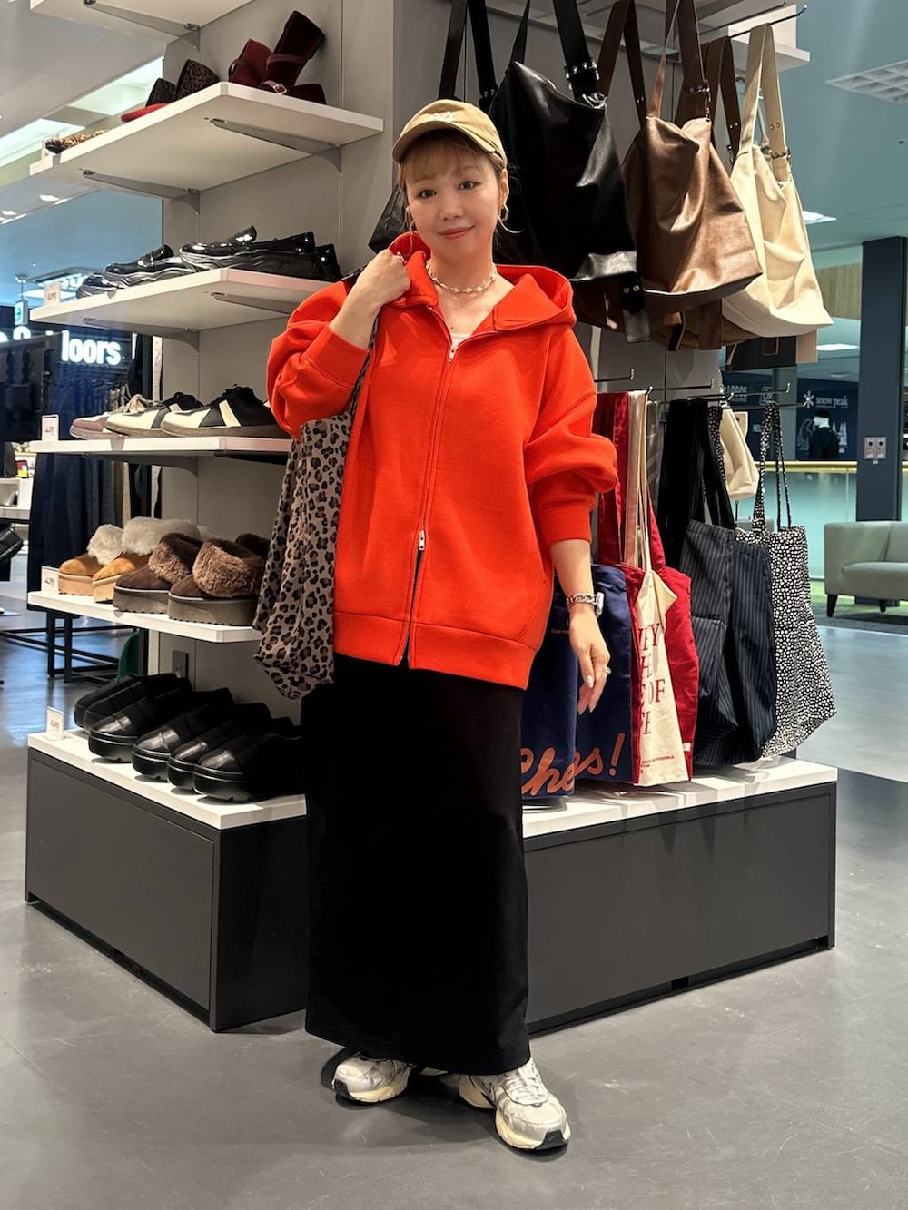 ブラック系のスカート、ベージュ系のトートバッグ、ホワイト系のタンクトップを着用したレディースの秋コーディネートの2枚目の写真