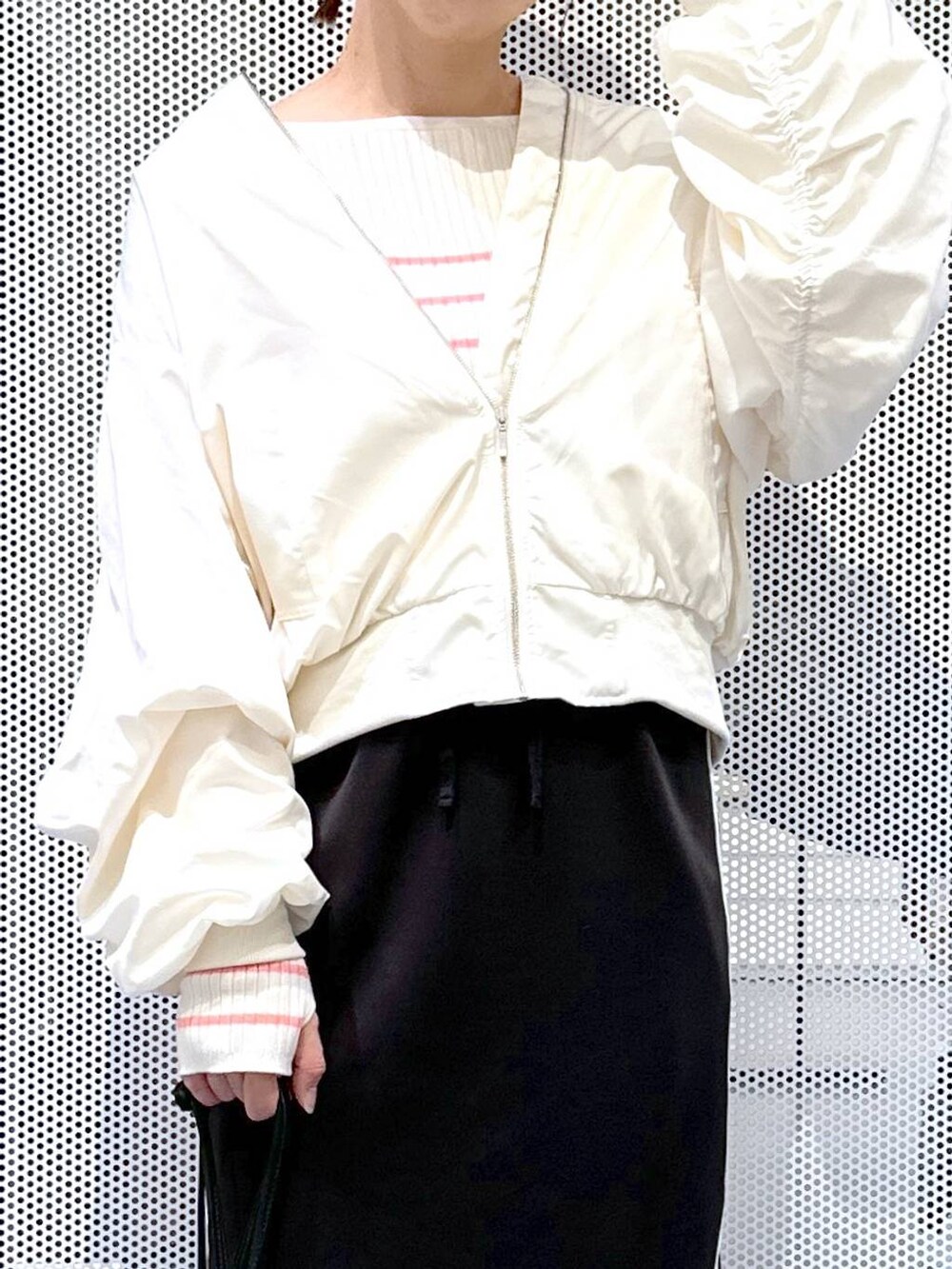 ブラック系のスカート、ベージュ系のMA-1、ピンク系のニット/セーターを着用したレディースの冬コーディネートの3枚目の写真