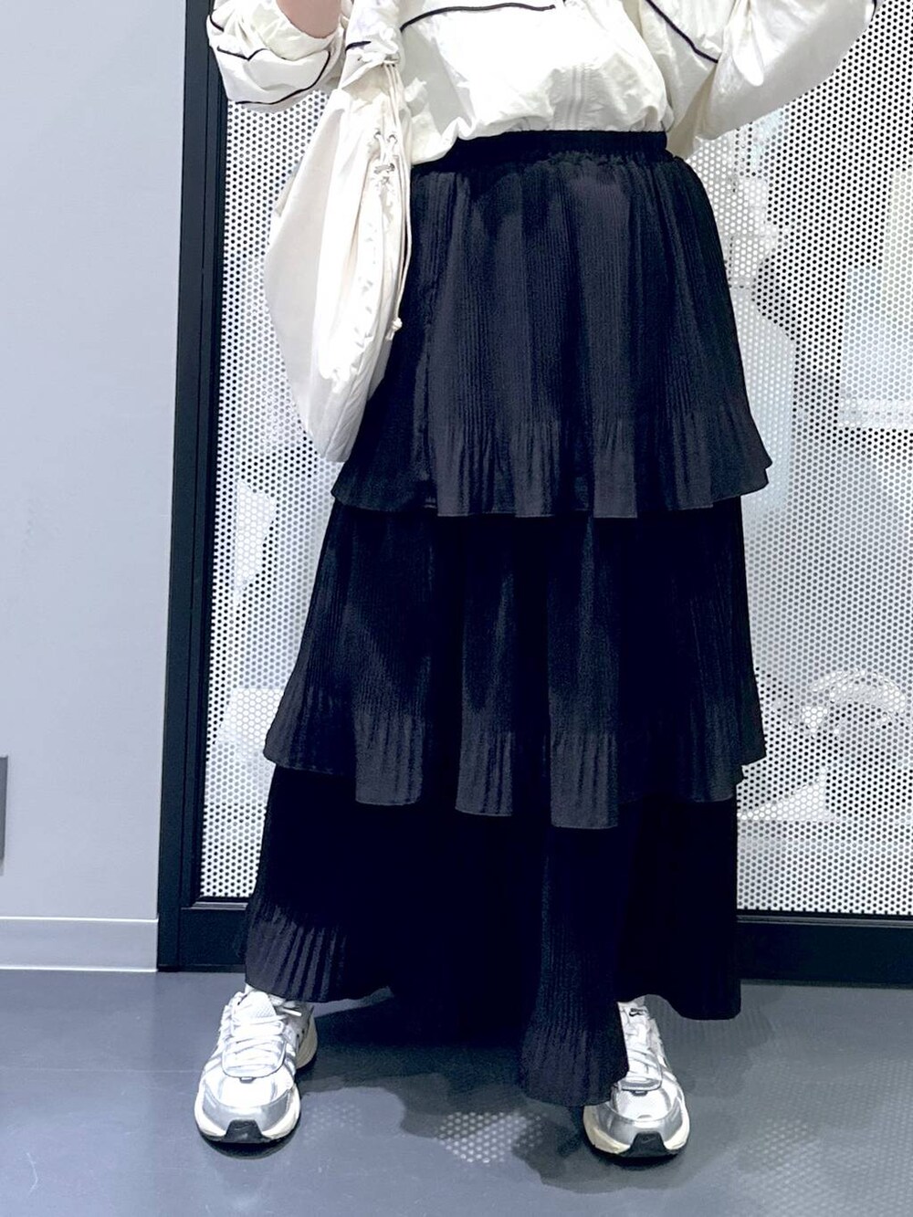 ブラック系のスカート、ホワイト系のショルダーバッグ、ベージュ系のブルゾンを着用したレディースの秋コーディネートの5枚目の写真