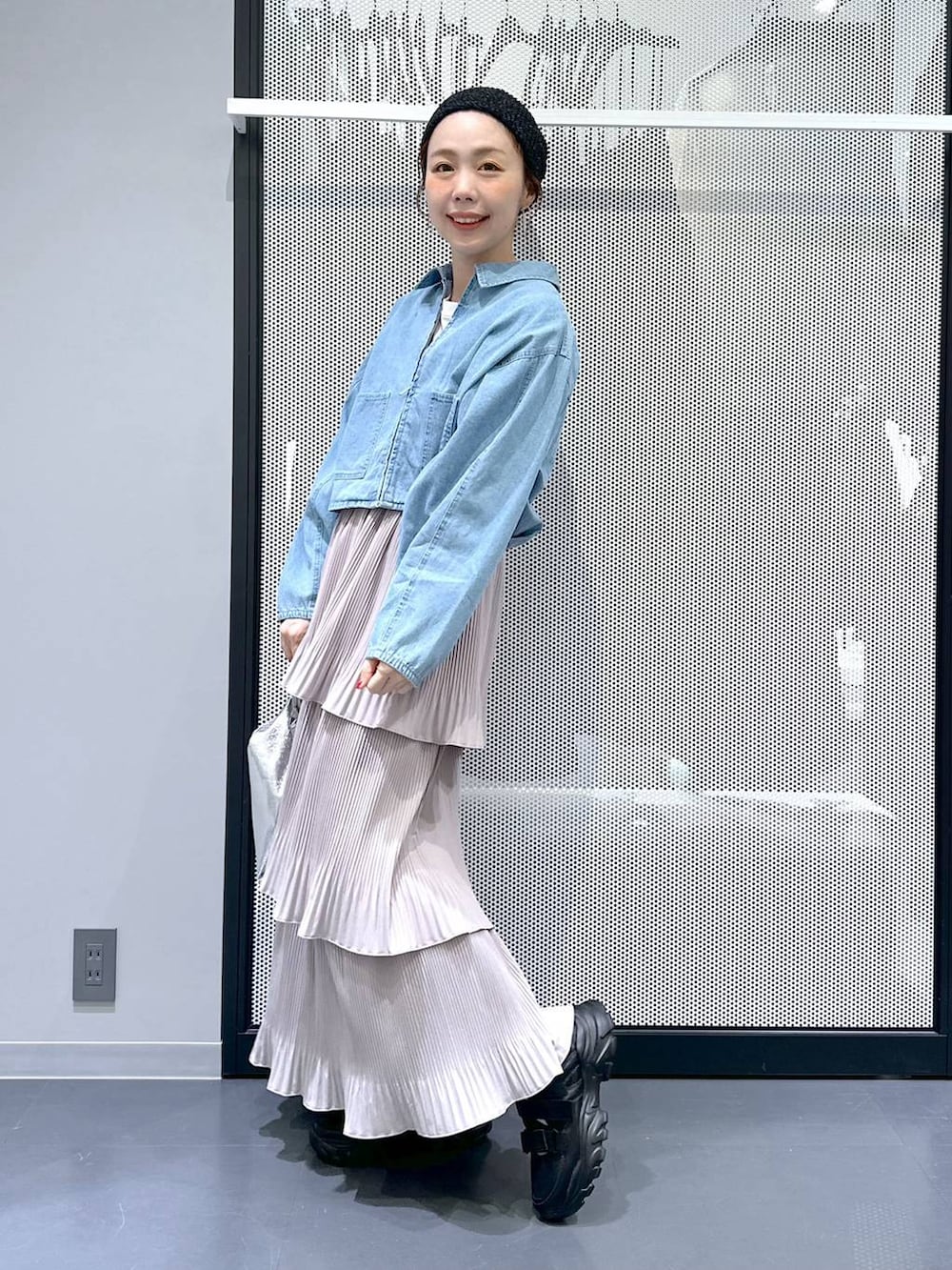 ブラック系のスニーカー、ブルー系のデニムジャケット、シルバー系のショルダーバッグを着用したレディースの春コーディネートの8枚目の写真