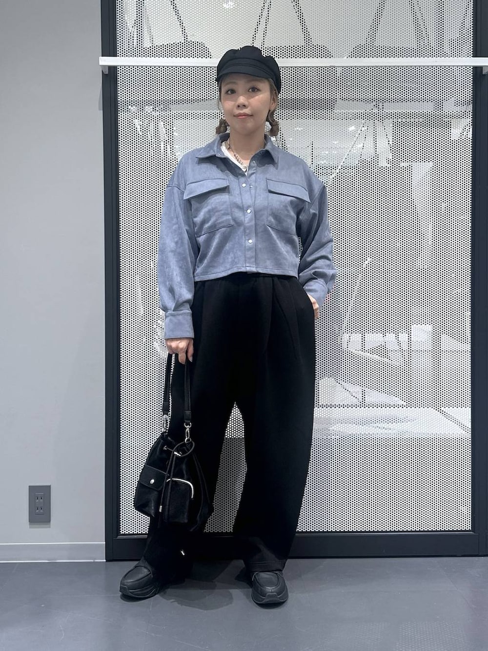 ホワイト系のタンクトップ、ブラック系のショルダーバッグ、ブラック系のスウェットパンツを着用したレディースの秋コーディネートの5枚目の写真