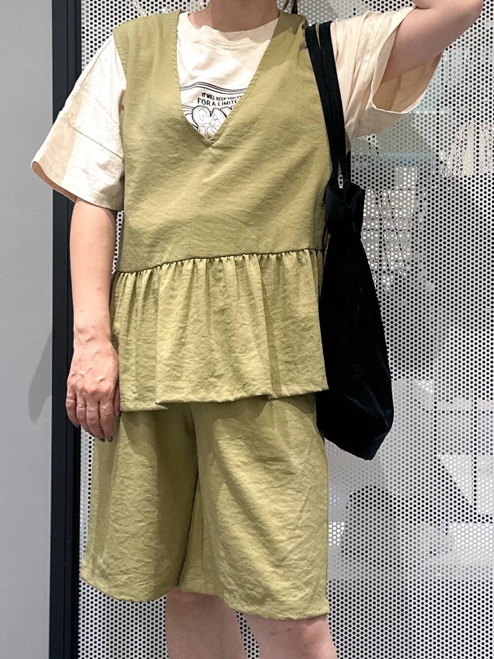 グリーン系のベスト、グリーン系のその他パンツ、ブラック系のトートバッグを着用したレディースの夏コーディネートの3枚目の写真