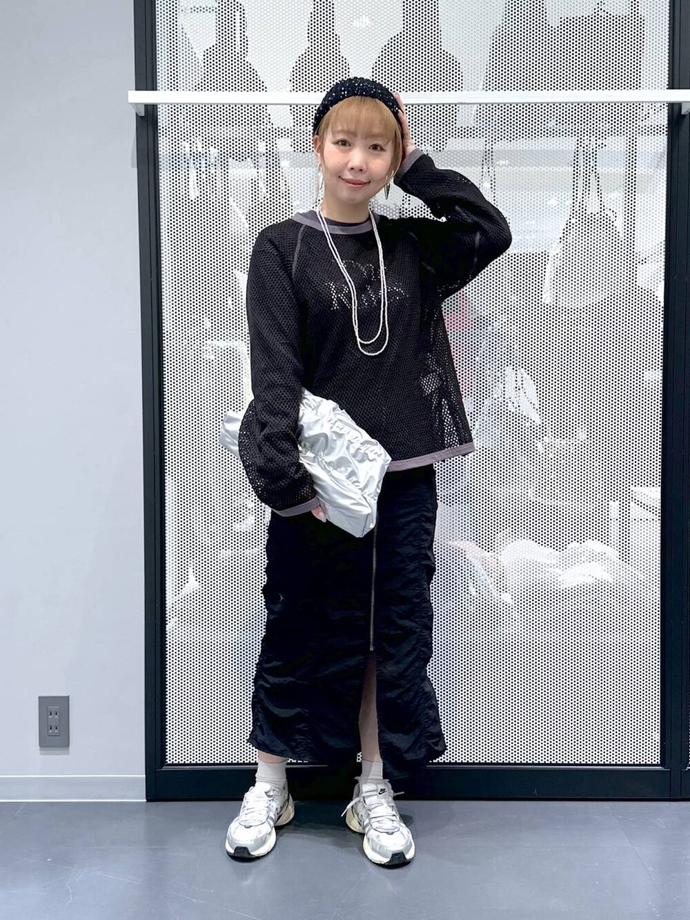 ブラック系のスカート、シルバー系のショルダーバッグ、グレー系のTシャツ/カットソーを着用したレディースの春コーディネートの2枚目の写真