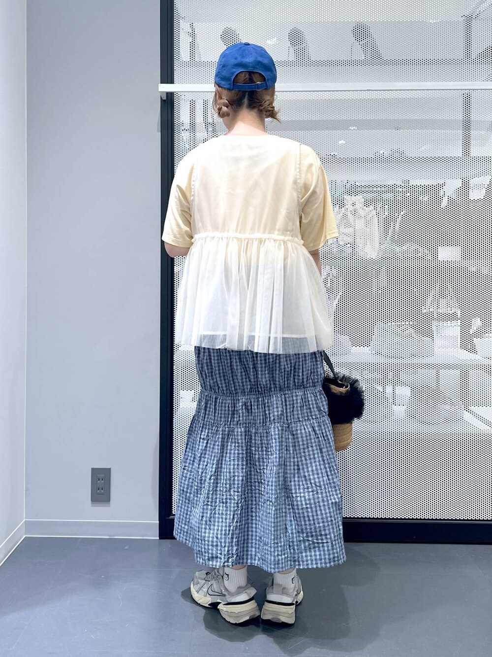 ベージュ系のショルダーバッグ、イエロー系のTシャツ/カットソー、ブルー系のスカートを着用したレディースの春コーディネートの4枚目の写真