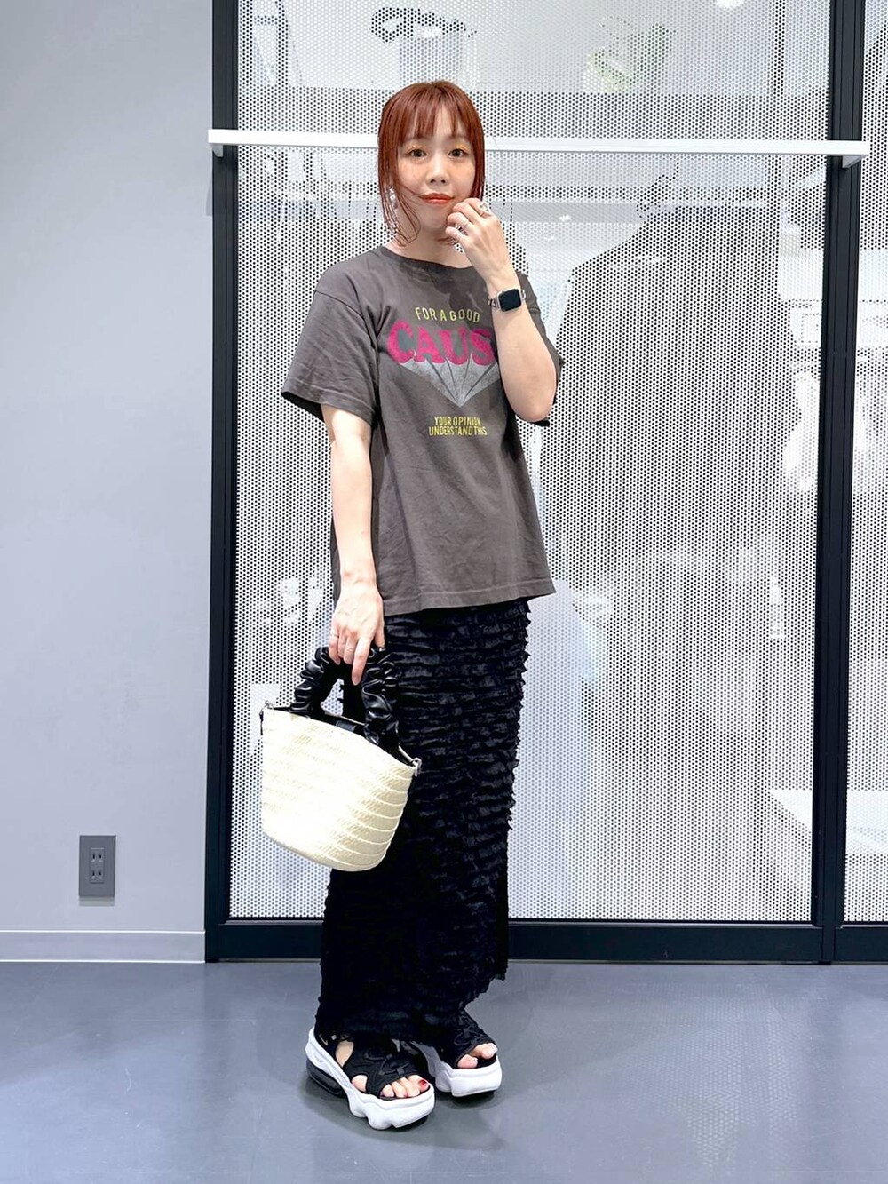 グレー系のTシャツ/カットソー、ブラック系のスカート、ホワイト系のショルダーバッグを着用したレディースの夏コーディネートの7枚目の写真