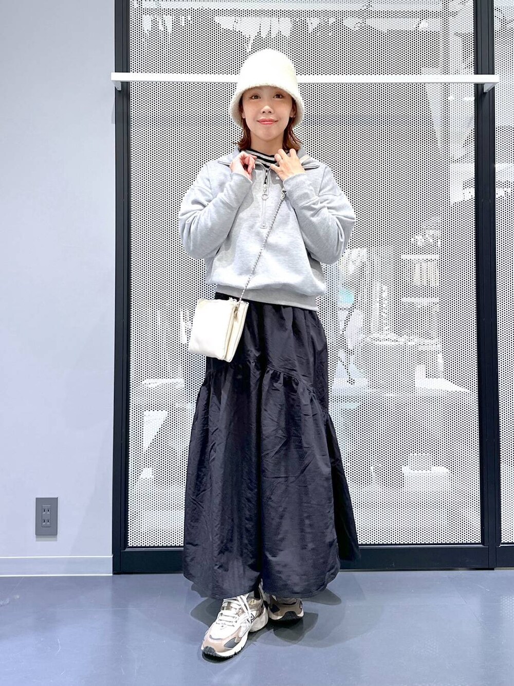 ブラウン系のスニーカー、ホワイト系のショルダーバッグ、その他のニット/セーターを着用したレディースの冬コーディネートの8枚目の写真