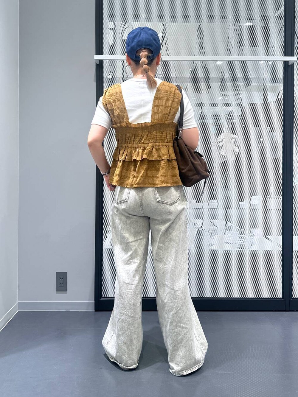 グレー系のデニムパンツ、ホワイト系のTシャツ/カットソー、ベージュ系のサンダルを着用したレディースの夏コーディネートの3枚目の写真