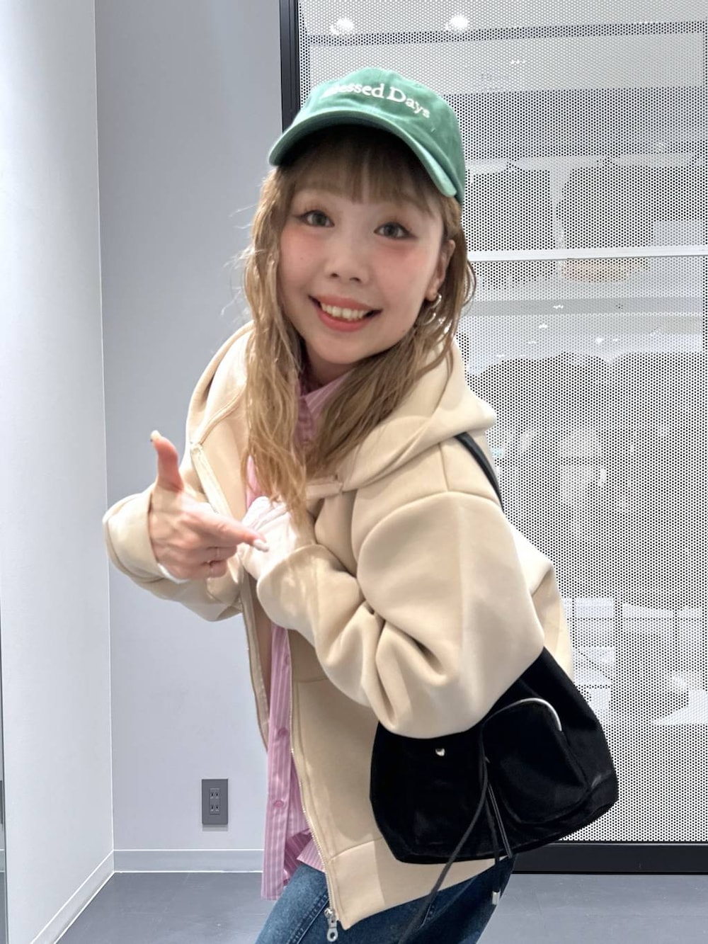 ホワイト系のTシャツ/カットソー、ブラック系のショルダーバッグ、ブルー系のデニムパンツを着用したレディースの冬コーディネートの9枚目の写真