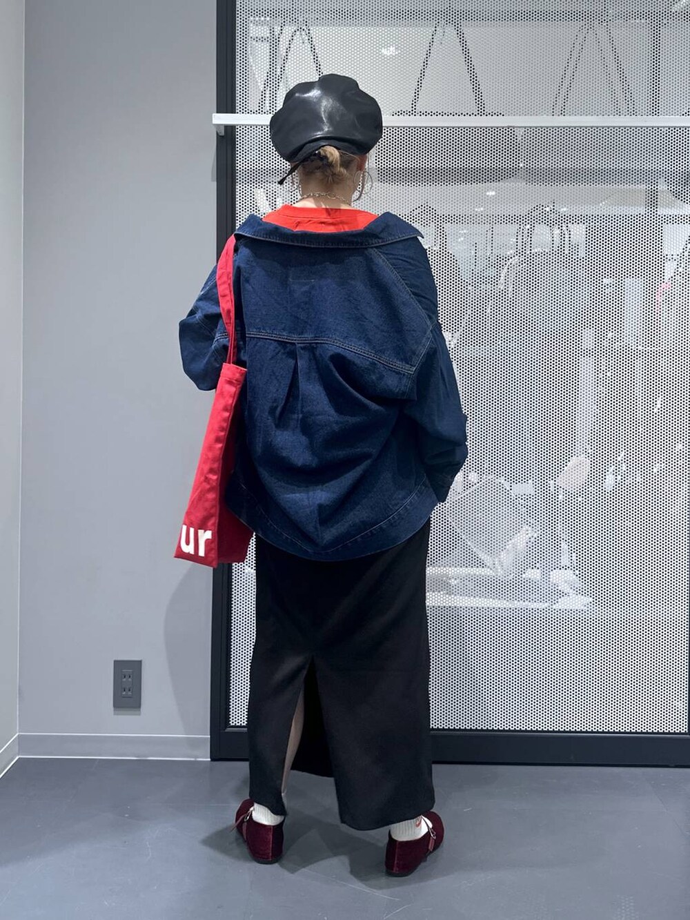 ブラック系のスカート、レッド系のトートバッグ、レッド系のパンプスを着用したレディースの秋コーディネートの3枚目の写真