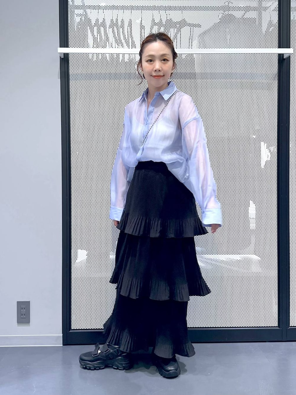 ブラック系のスニーカー、ブラック系のスカート、ブルー系のシャツ/ブラウスを着用したレディースの春コーディネートの3枚目の写真