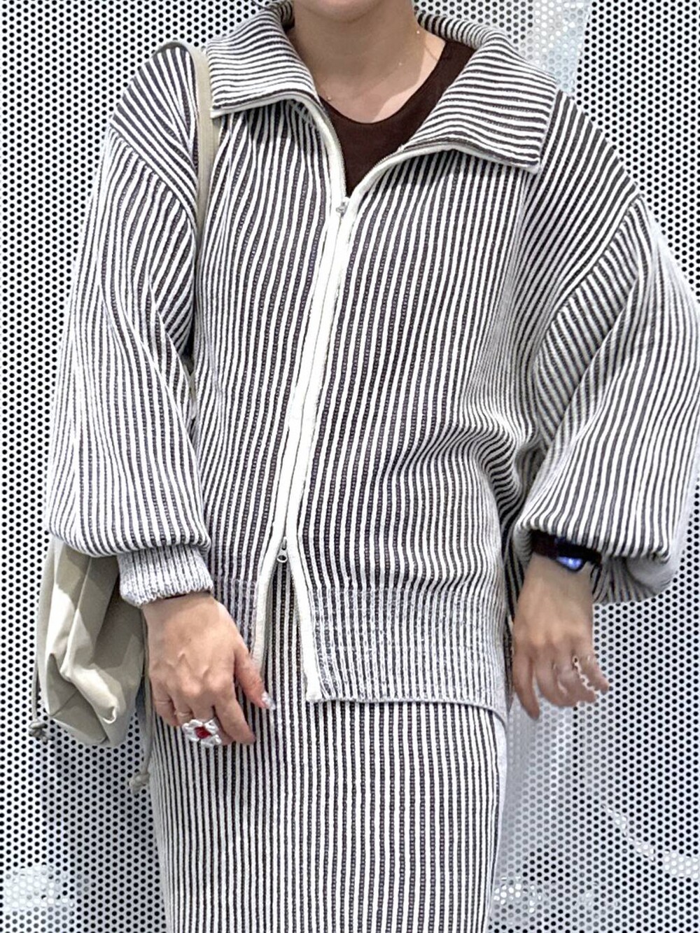 ベージュ系のトートバッグ、ベージュ系のスカート、ベージュ系のニット/セーターを着用したレディースの秋コーディネートの4枚目の写真