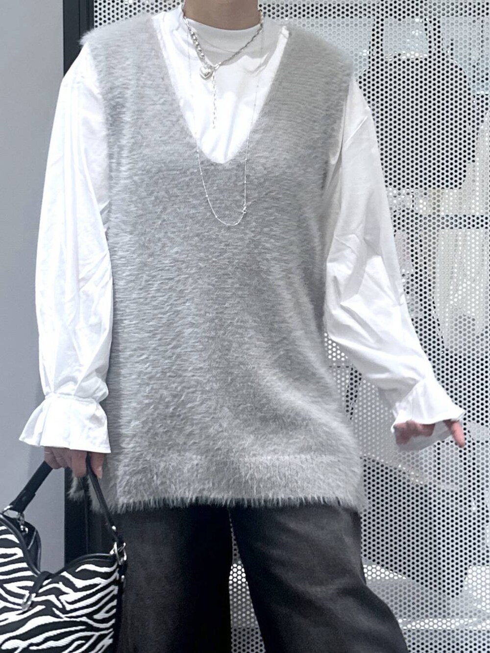 ブラック系のデニムパンツ、その他のショルダーバッグ、グレー系のベストを着用したレディースの秋コーディネートの4枚目の写真